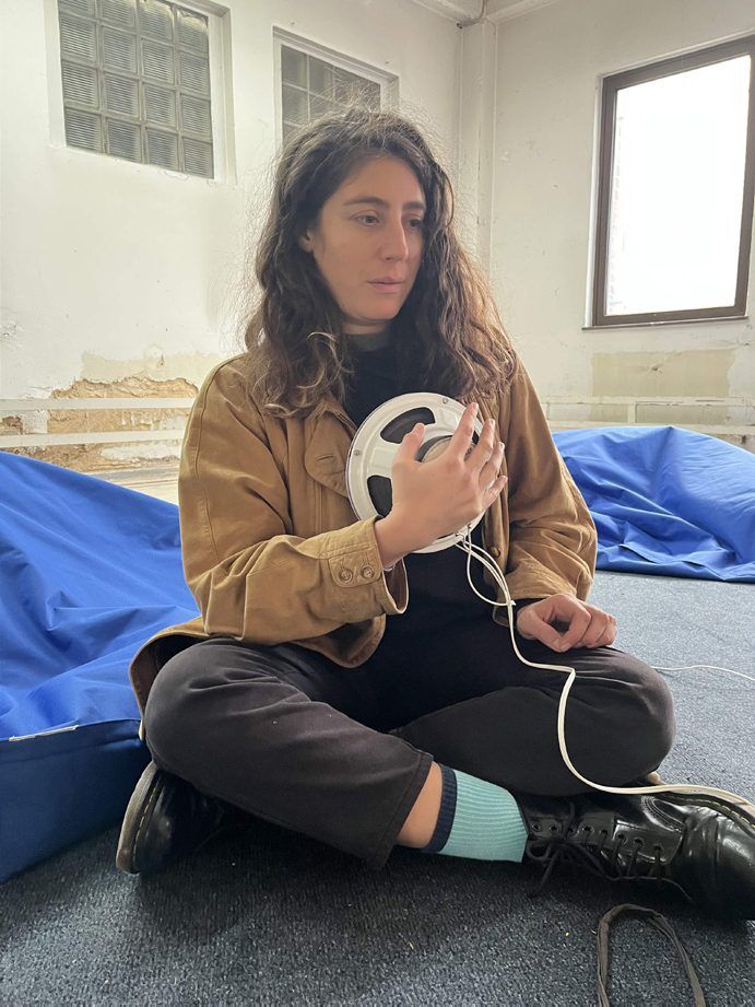 A visitor holds a loudspeaker sphere against her body