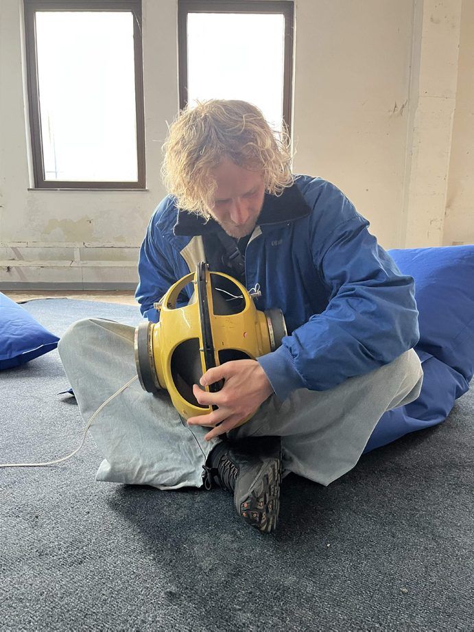A visitor holds the yellow loudspeaker sphere